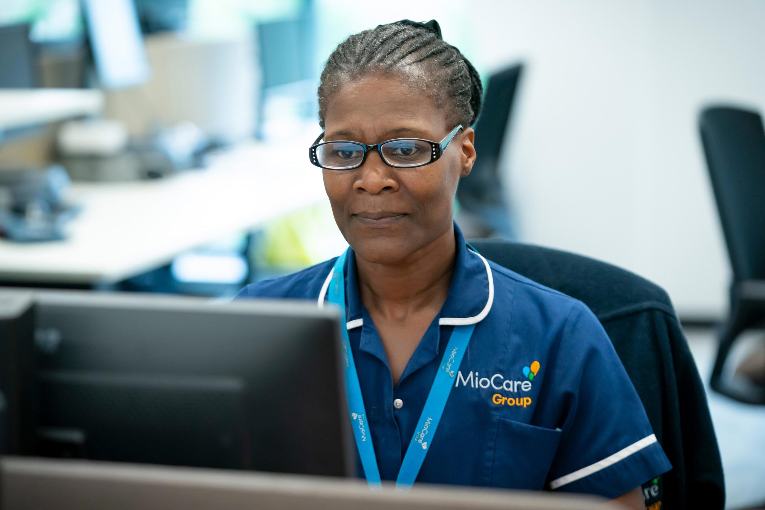 MioCare staff member working at a computer in a care office.
